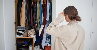 クローゼットで悩む女性